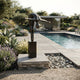 Life-Size Modern Abstract Diving Figure Bronze Sculpture by Giant Sculptures on a matching plinth beside a pool, with lavender, succulents and a garden pavilion.