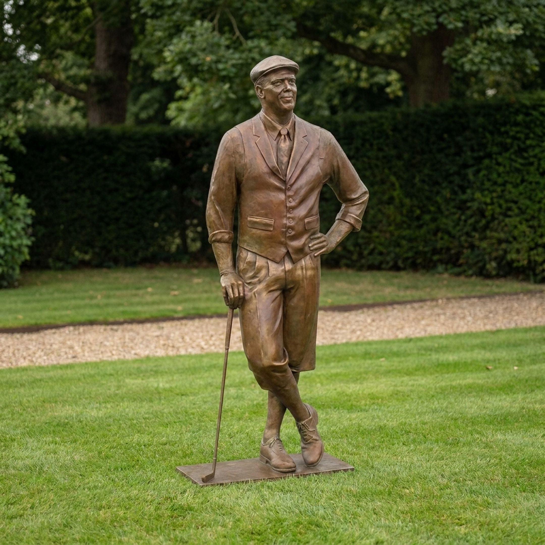 Life-Size Traditional Male Golfer Bronze Sculpture by Giant Sculptures shown on a lawn, in flat cap and knickerbockers, leaning on a golf club.
