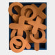 The Typova Burnt Orange X&O Wood Carving 3D Wall Art by Giant Sculptures features large, overlapping orange X and O pieces in a blue tray—perfect as striking Nordic decor or unique burnt orange wall art.
