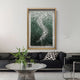 A modern living room with a black sofa, a black-and-white spotted pillow, a glass coffee table topped with a green leafy plant, and the Spiravale Green Gradient Floral Curl 3D Wall Art by Giant Sculptures on a light gray wall.