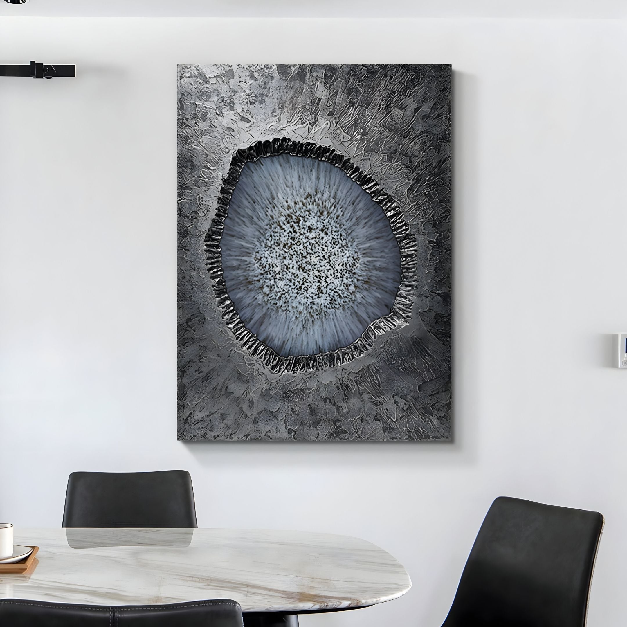 A modern dining area features a round marble table with black chairs. The crisp white wall is adorned with Giant Sculptures’ Vorthera Frost Halo Textured Silver 3D Wall Art, adding a striking contemporary touch.