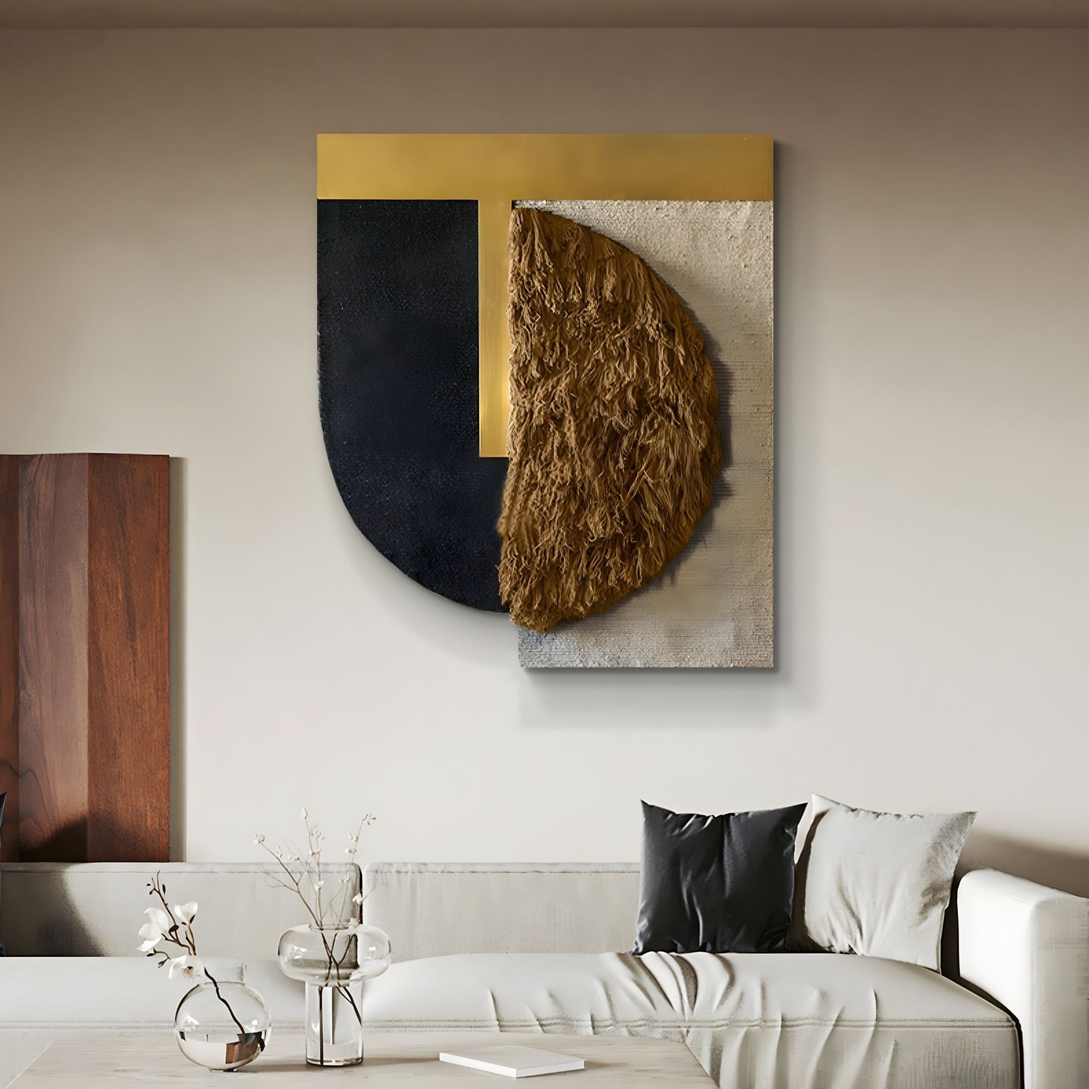 Halvoria Black & Umber Fibre Shield 3D Wall Art by Giant Sculptures hangs above a modern beige sofa, showcasing geometric black, gold, and cream shapes with a textured brown semicircle. Minimalist decor is accented by a glass vase with light branches.