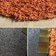 Halvoria Grey & Terracotta Fibre Panel 3D Wall Art by Giant Sculptures features textured orange fringe on beige with a black background and brass strip, bringing bold dimension to contemporary interiors.