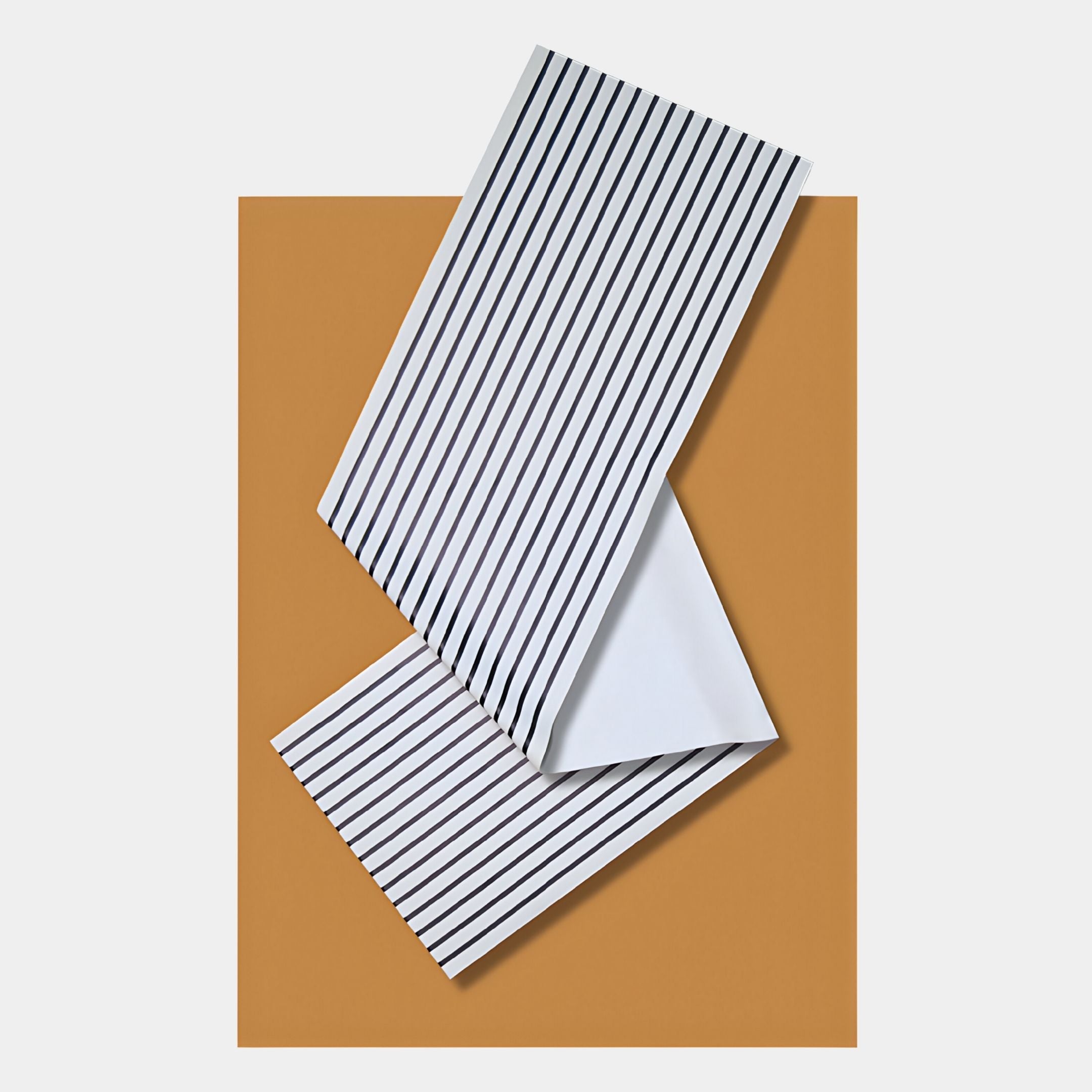 The Arcluma Amber Stripe Fold Leather 3D Wall Art by Giant Sculptures features two white sheets with black stripes, overlapped at an angle on a solid brown background—a striking minimalist piece for modern interiors.