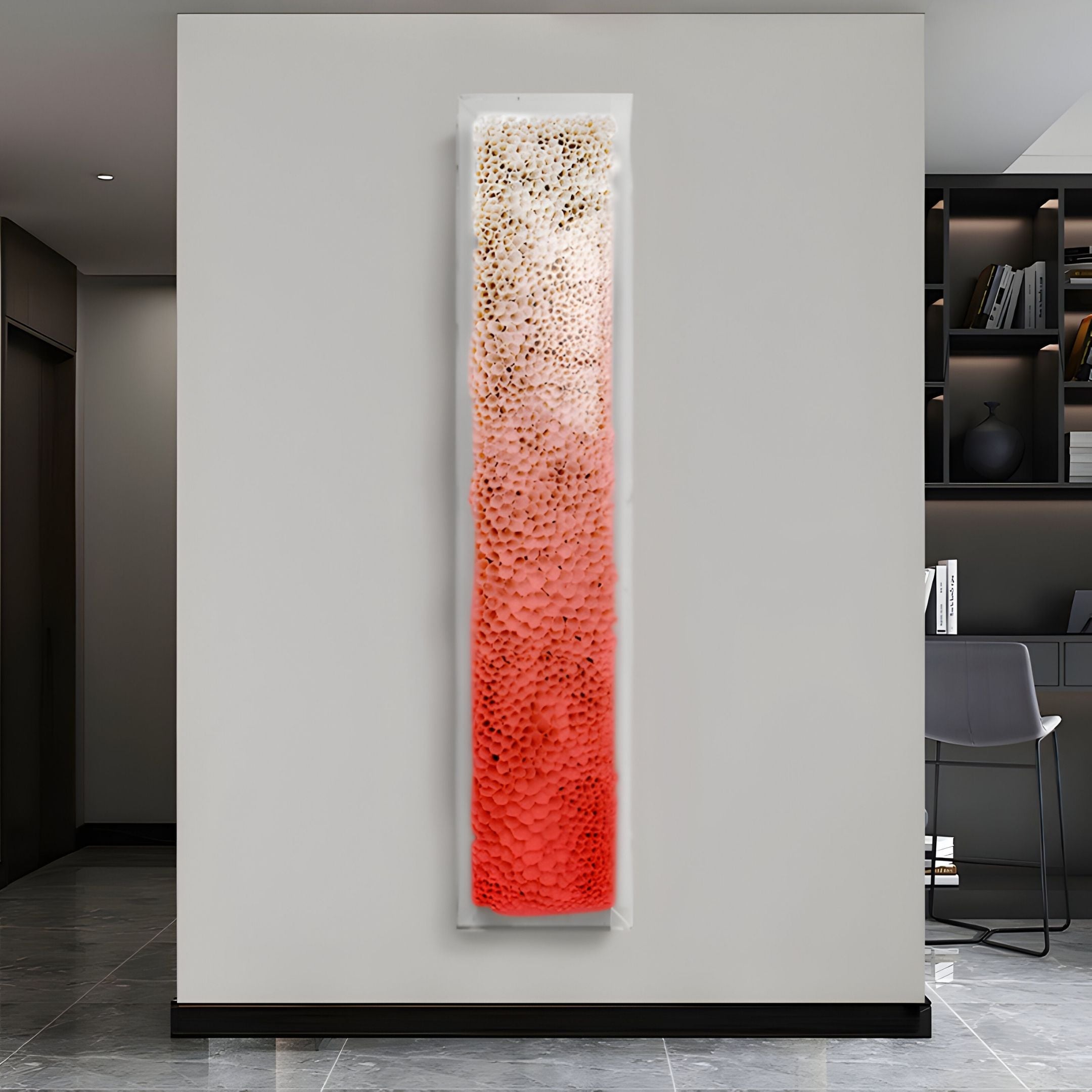 The Aeraline Coral Bloom Vertical Gradient Leather 3D Wall Art by Giant Sculptures features a tall, narrow rectangle with textured circles fading from white to vibrant red, displayed on a light gray wall in a modern setting.
