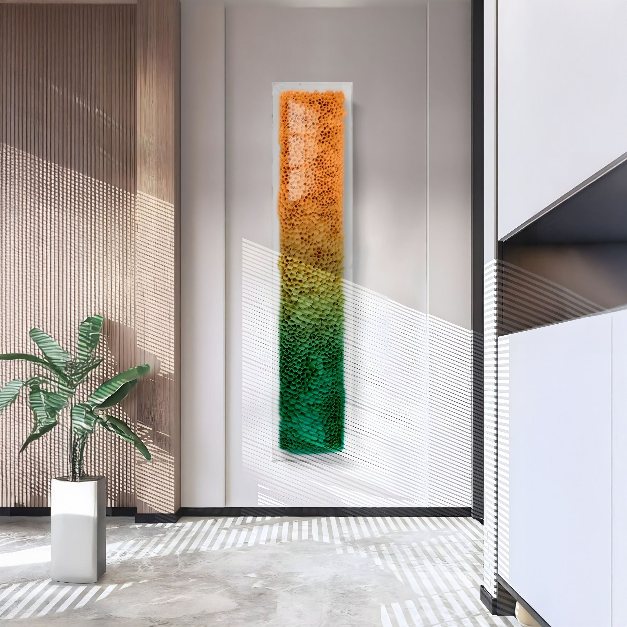 A modern interior features the Aeraline Amber Green Vertical Gradient Leather 3D Wall Art by Giant Sculptures. Sunlight casts striped shadows onto a concrete floor, where a potted plant adds to the contemporary atmosphere.
