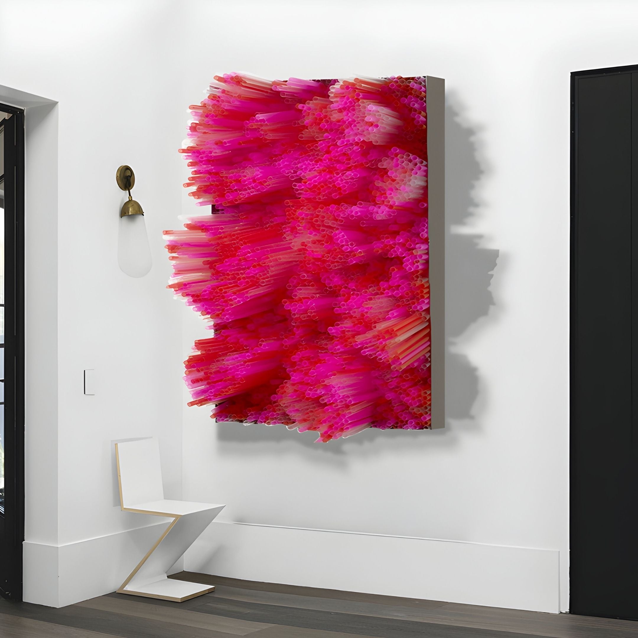 The Chromavolt Fuchsia Burst Straw 3D Wall Art by Giant Sculptures features vibrant pink and magenta textured spikes, adding bold flair to modern decor in a minimalist room with white walls, a geometric white chair, and a black door.