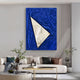A modern living room with a white sofa, glass coffee table, and plants. Above the sofa is the Arclunor Cobalt Blue Triangle Relief Mirror 3D Wall Art by Giant Sculptures, reflecting part of the space.
