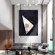 A modern living room with high ceilings features the Giant Sculptures Arclunor Black Triangle Relief Mirror 3D Wall Art, marble walls, contemporary white and brown chairs, a round glass coffee table, and dramatic black-framed abstract accents.