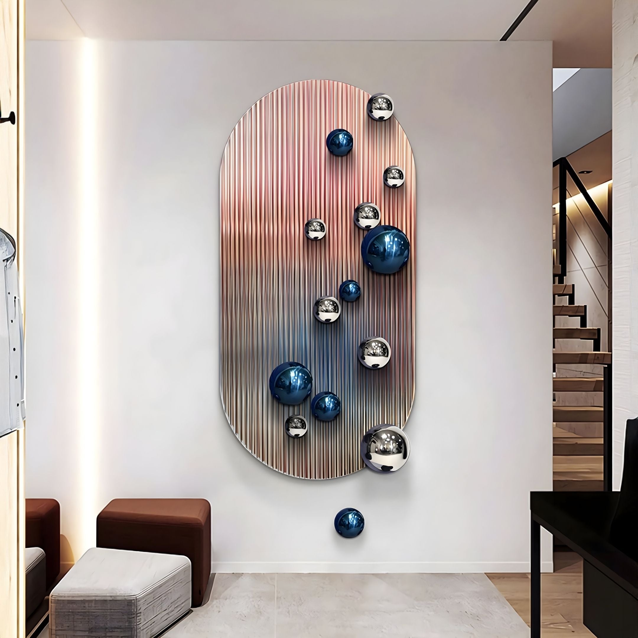 The Virellon Rose Gradient 3D Wall Art with Blue & Silver Metal Balls by Giant Sculptures adds striking contemporary decor to a stylish hallway, featuring an oval panel with vertical ridges and reflective spheres beside a staircase and seating.
