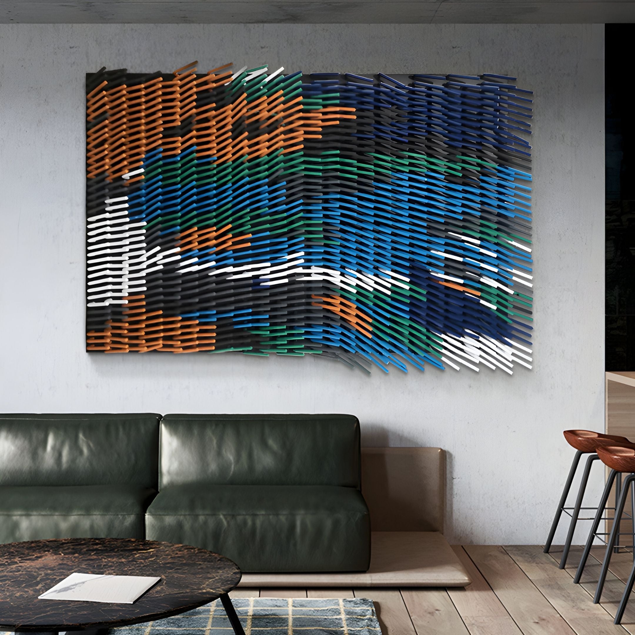A modern living room with a green leather sofa, round table, and a bold statement piece: the Waverno Blue & Green Flow Metal 3D Wall Art by Giant Sculptures, featuring layered slats in blue, green, orange, white, and black tones.