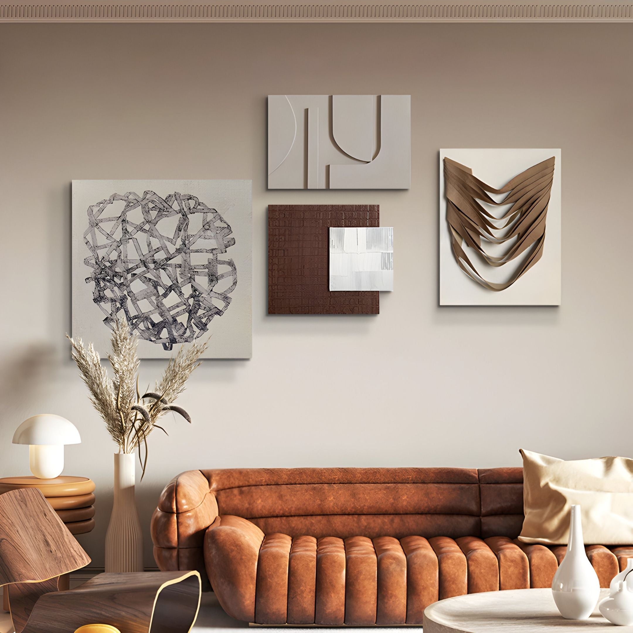 A modern living room with a brown leather sofa, wooden and white accent furniture, dried grasses in a vase, and the Mirello 4-Set Neutral Sculptural Mixed Media 3D Wall Art by Giant Sculptures arranged on a light beige wall.