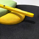 Close-up of Solvia Green & Yellow Layered Geometry 3D Wall Art by Giant Sculptures, featuring a textured surface with round yellow and light green cushions plus a bright yellow wooden bar—an eye-catching piece of contemporary decor.