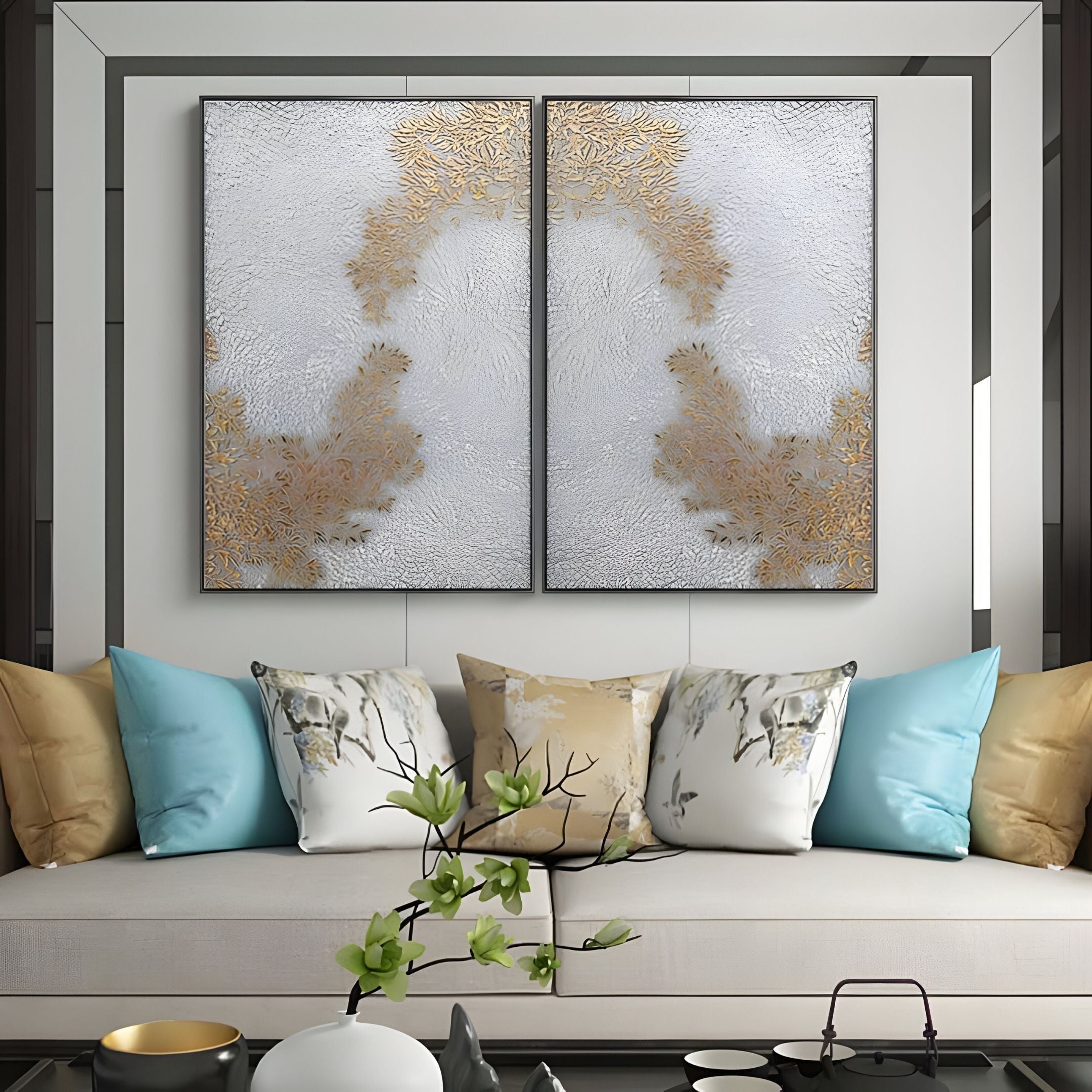 A modern living room with a beige sofa, blue and marble-patterned pillows, a minimal plant on a low table, and the Lunavine Gold Leaf Textured Silk Relief 3D Wall Art by Giant Sculptures in gold and white hanging above the sofa.
