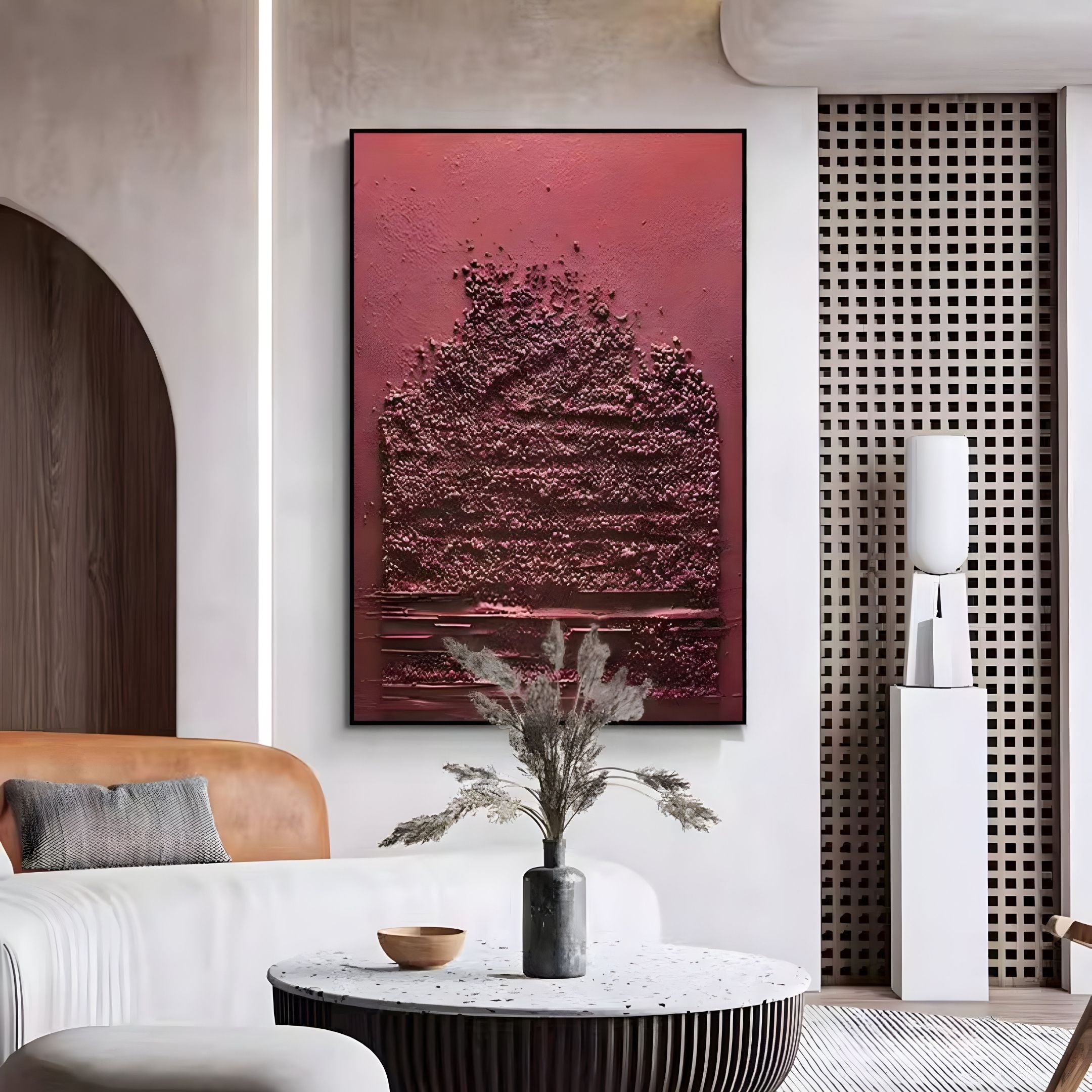 A modern living room showcases the Aeralune Crimson Textured Oil Painting 3D Wall Art by Giant Sculptures, a round white coffee table with a dark vase of dried grasses, a tan sofa, and neutral minimalist accents.