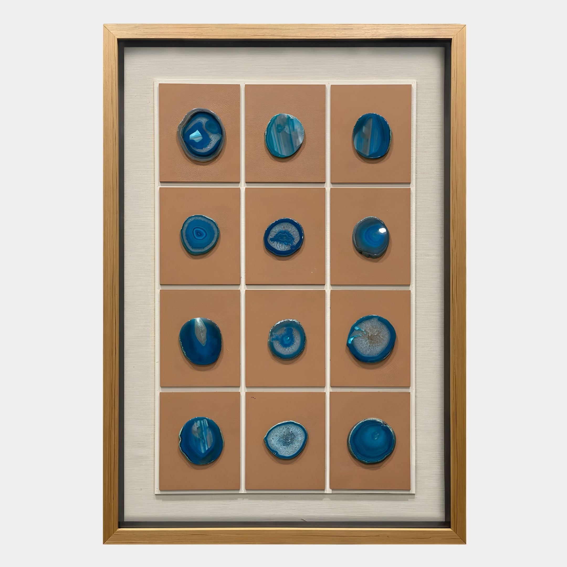 The Agliera Aqua Crystal Disc Grid Framed 3D Wall Art by Giant Sculptures features twelve blue agate discs in a wooden frame, arranged in a 3x4 grid with tan backgrounds—an ideal accent for modern interiors.