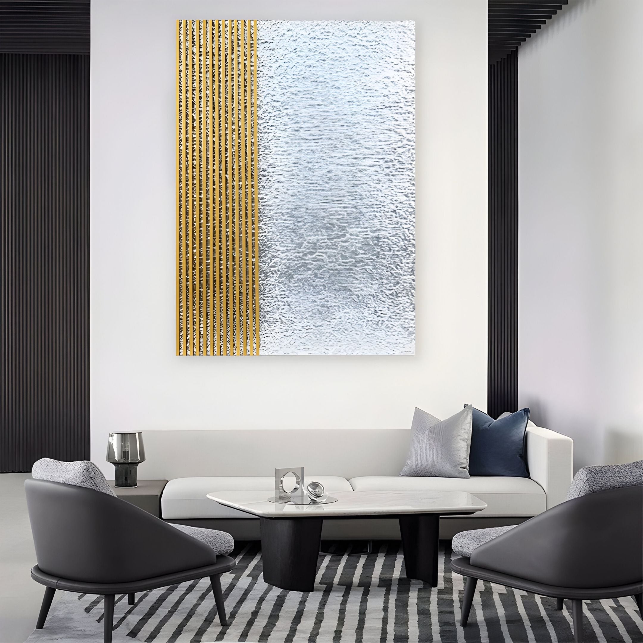 A modern living room with gray chairs, a white sofa, and a marble coffee table. Above the sofa hangs Giant Sculptures’ Metallure Gold Linear Textured Acrylic Silver Foil 3D Wall Art for a chic, contemporary touch.