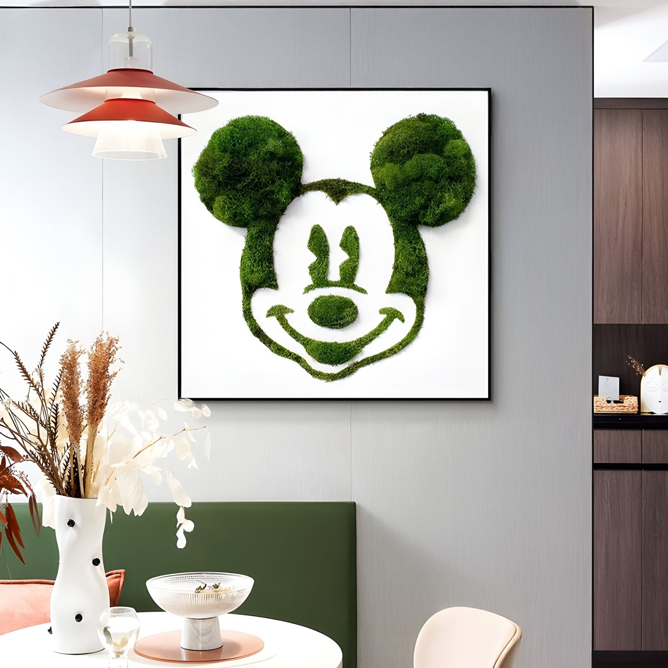 A modern dining area showcases the Verdifable Square Green Mouse Silhouette Moss 3D Wall Art by Giant Sculptures above a bench, paired with a white vase of dried flowers and a pendant light—ideal for Nordic decor.