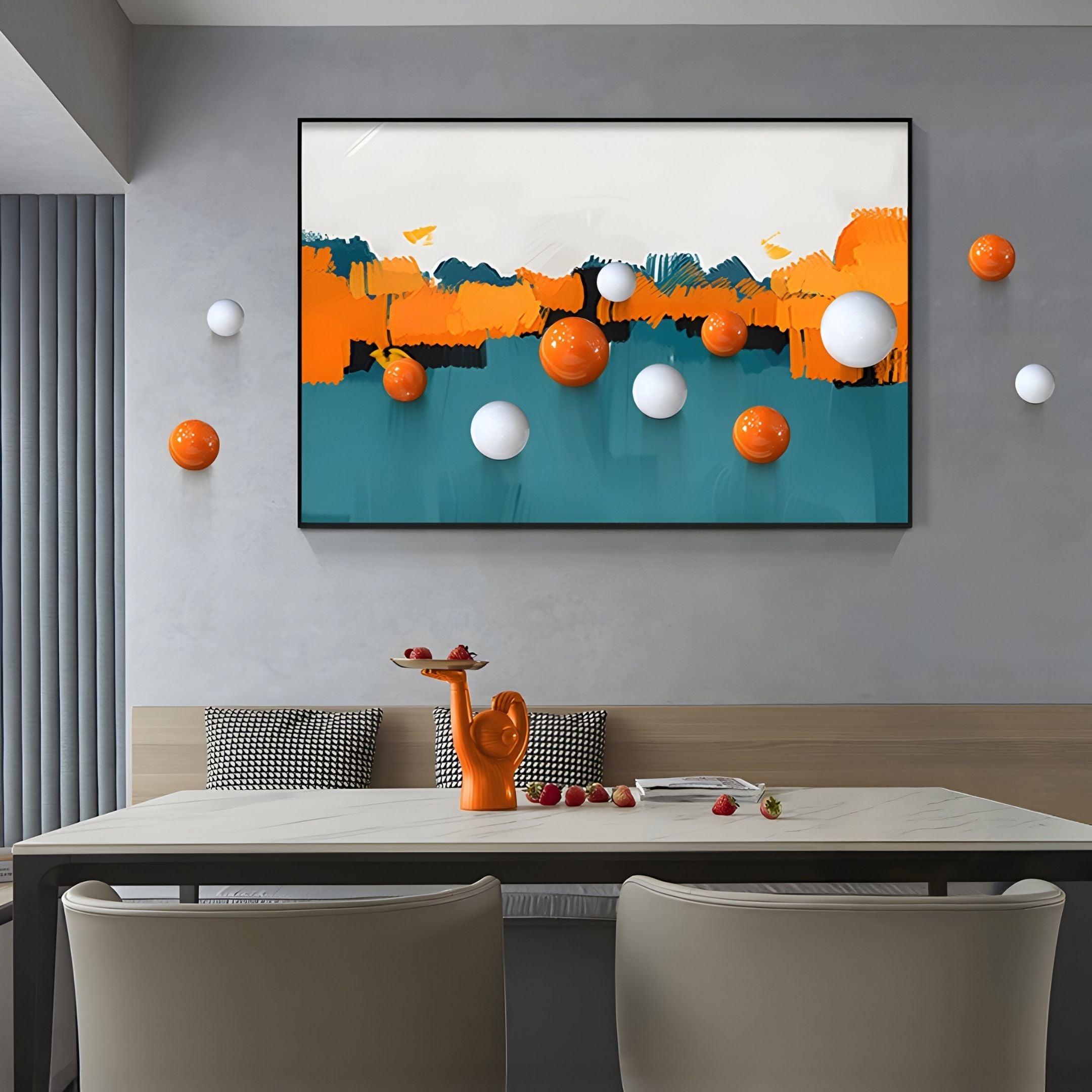 A modern dining area showcases Giant Sculptures' Aerisphere Abstract Drift 3D Wall Art with orange, blue, and white hues and decorative metal spheres. An orange teapot sits on the table alongside fresh fruit.