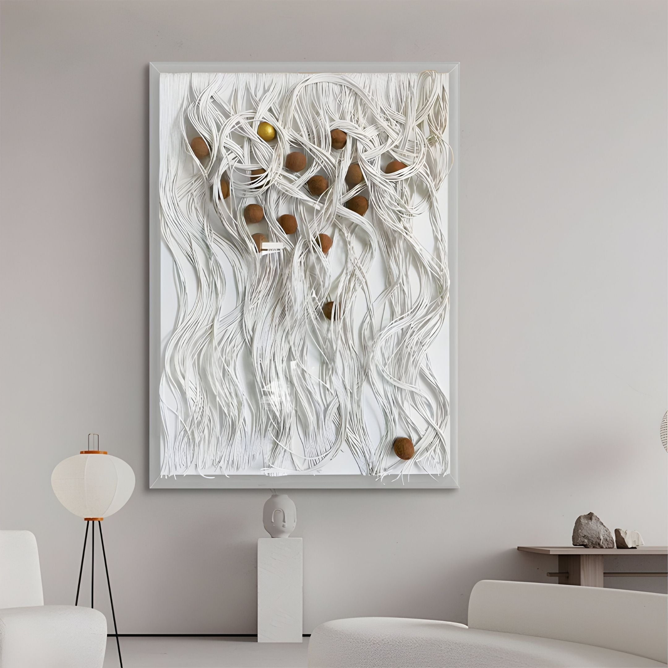 A modern living room showcases Giant Sculptures' Strandeva White Weave & Walnut Sphere 3D Layered Wall Art above a white mantel sculpture, complemented by minimalist white furniture and a distinctive floor lamp.