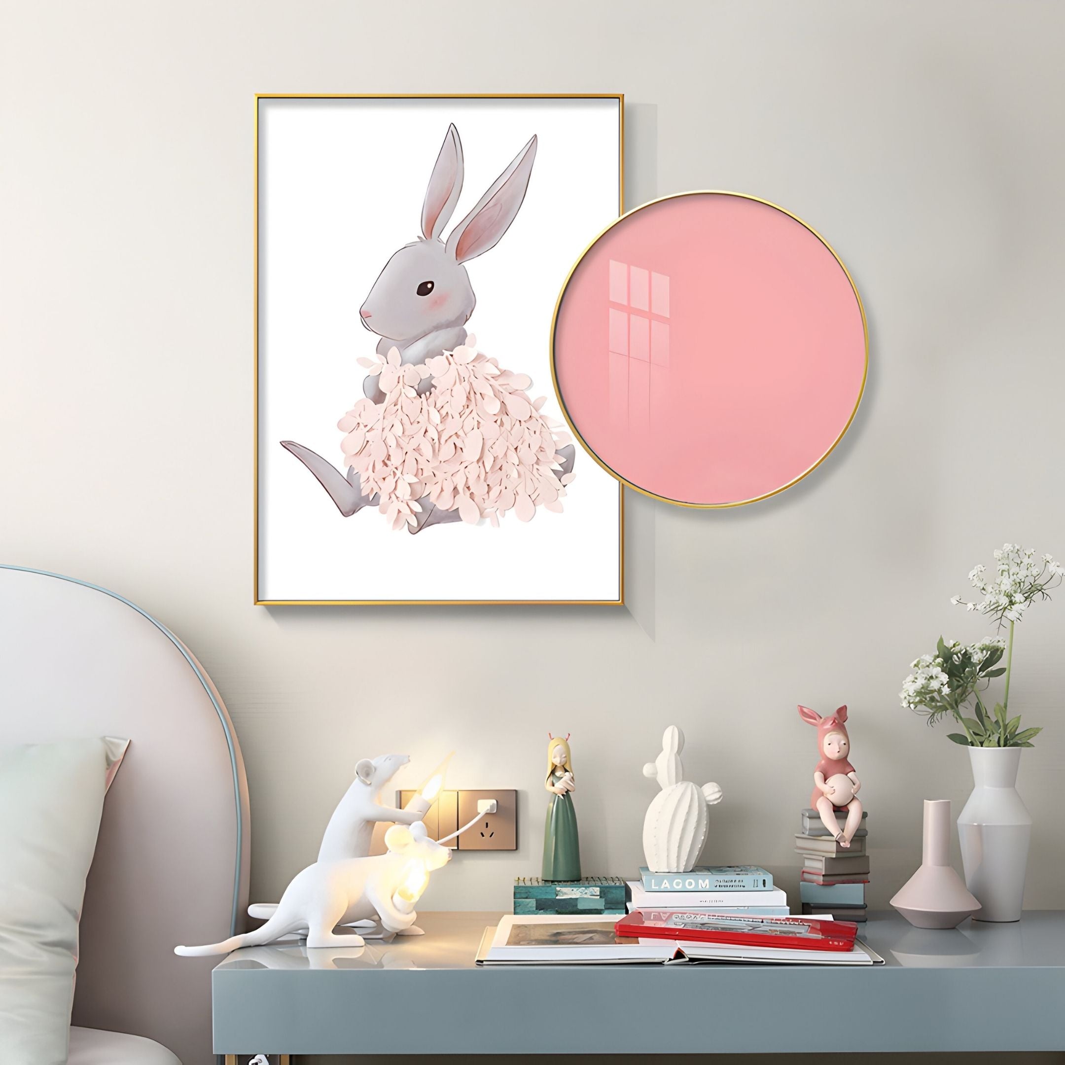 A pastel bedroom corner with a bed, bunny decor, books, a rabbit lamp, animal and flower figurines, a pink mirror, a vase of white flowers, and the Blossomkin Pink Petal Bunny Kids 3D Wall Art by Giant Sculptures on the wall.