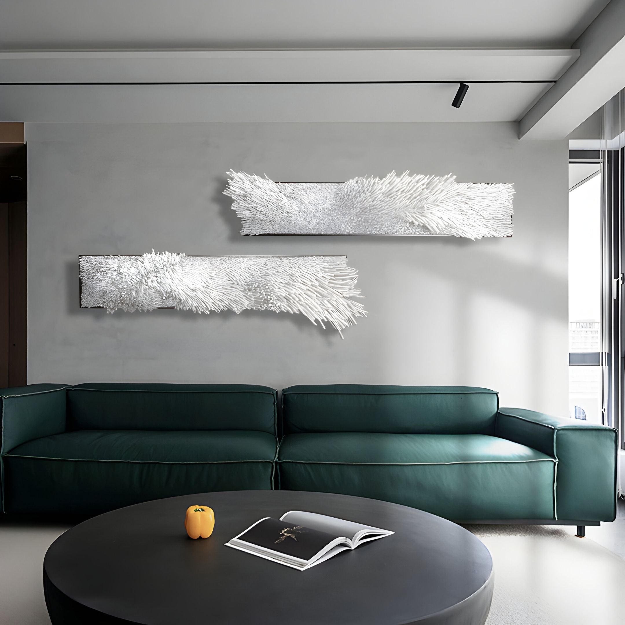 A modern living room with a dark green sofa, a round black coffee table holding an open book and a small orange item, and Bristella White Textured 2-Panel 3D Wall Art by Giant Sculptures as contemporary decor above the sofa.