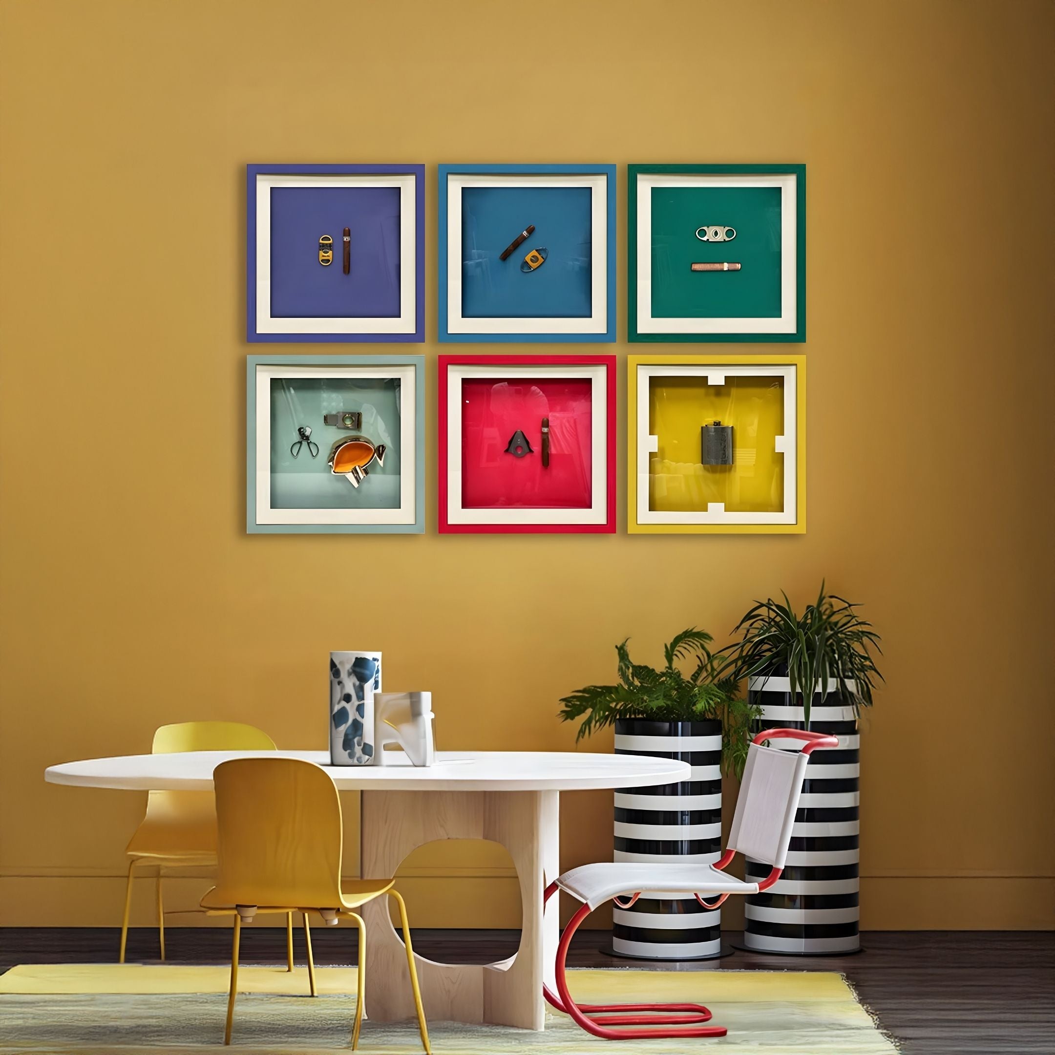 A modern dining area features a round white table, yellow and white chairs, striped plant pots, mustard yellow walls, and six framed art pieces from Giant Sculptures, including the Cavallero Red Cigar & Cutter Framed Wall Art.