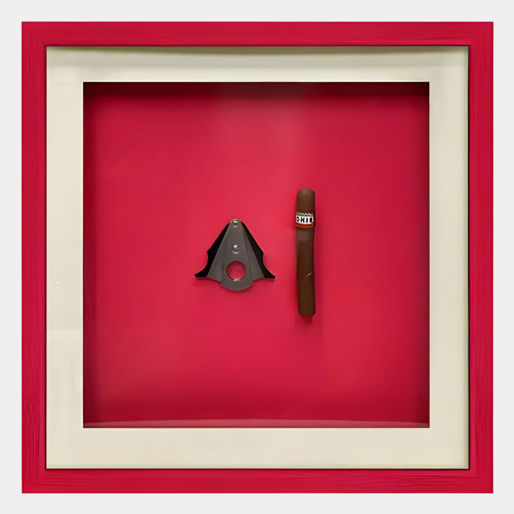 The Cavallero Red Cigar & Cutter Framed Wall Art by Giant Sculptures features a vivid red background with a metal cigar cutter and brown cigar, elegantly displayed in a white mat and red frame—perfect bold decor.