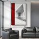 A modern living room showcases gray leather sofas and the Arclustre Red & White Grand Hall Perspective 3D Wall Art by Giant Sculptures, featuring contemporary red, white geometric shapes and a black-and-white grand corridor photo.