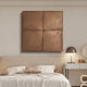 Minimalist bedroom with a cream tufted headboard, unmade bed, white nightstand, modern lamp, and Giant Sculptures’ Terracrecta Cocoa Brown Painted Textured Square 3D Wall Art featuring four panels above the bed.