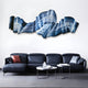 A modern living room features a dark blue sectional with red and gray pillows, two round coffee tables, and Giant Sculptures’ Vellun Wave Midnight Blue Sculptural 3D Wall Art above the couch, evoking the look of blue waves.