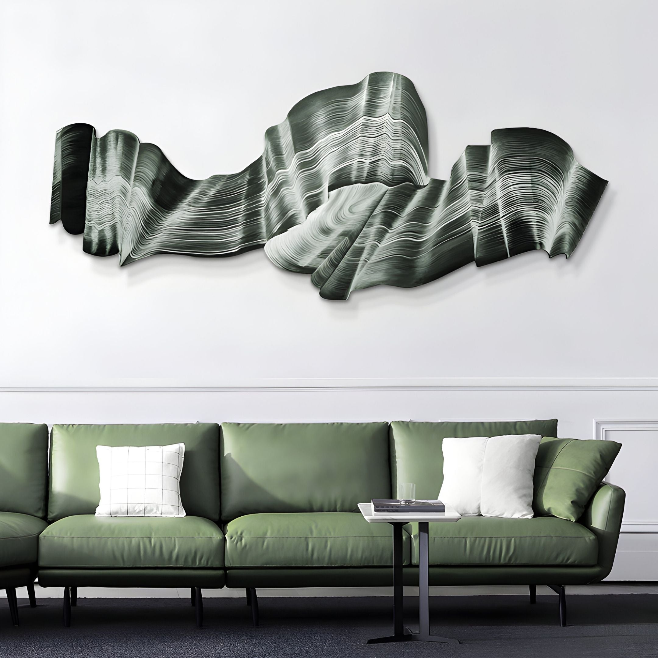 A green curved sofa with white pillows sits beneath the Vellun Wave Forest Shadow Sculptural 3D Wall Art by Giant Sculptures in a modern living room with white walls and minimalist decor.