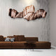 A modern living room with a brown sectional sofa, a black and white geometric pillow, two round nesting tables, and the Vellun Wave Bronze Drift Sculptural 3D Wall Art by Giant Sculptures as a striking feature against a textured gray wall.
