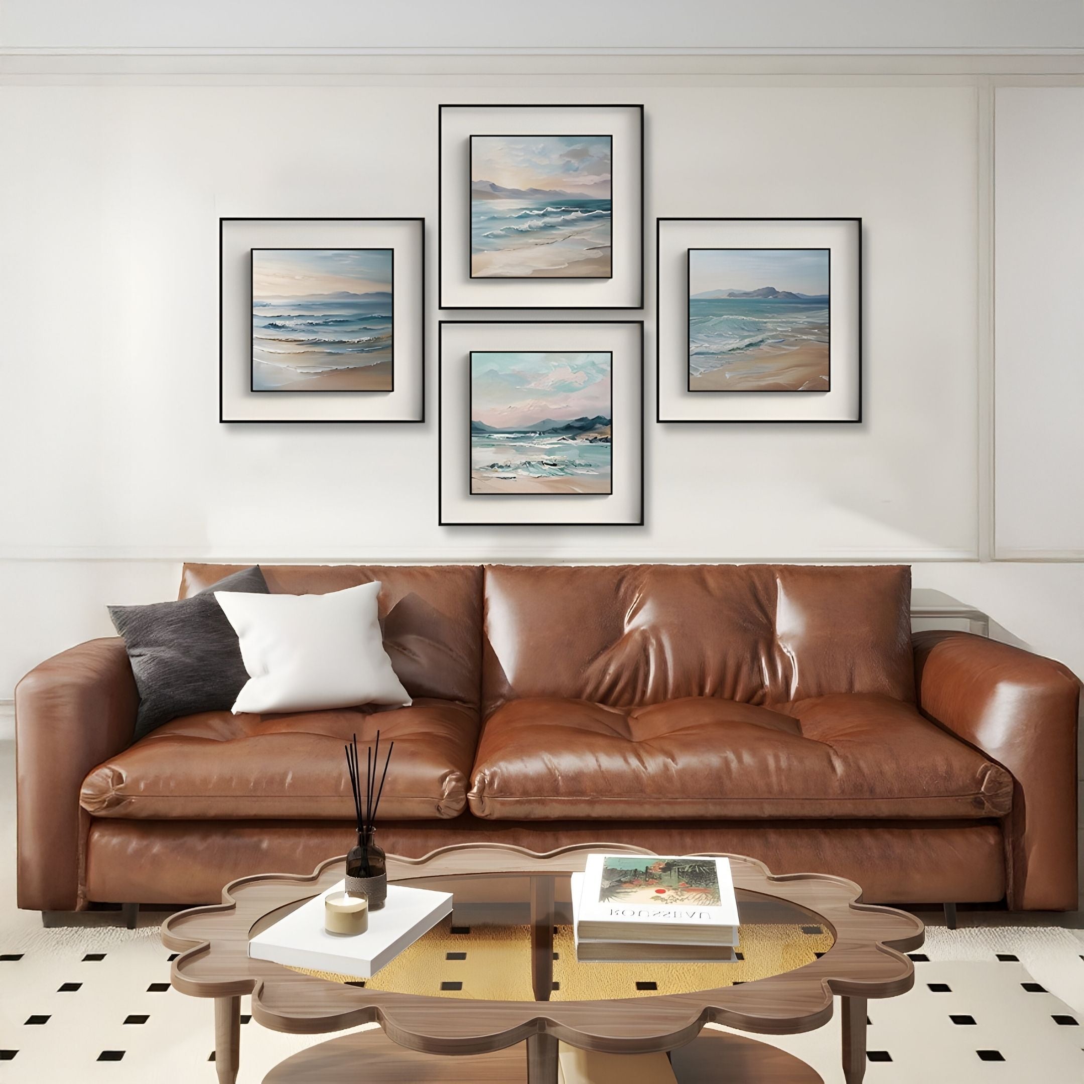 A brown leather sofa with white and gray pillows sits against a white wall, topped by four Marilline III Calm Coastal View Double Framed Wall Art pieces by Giant Sculptures. A wooden coffee table with books and decor stands in front.