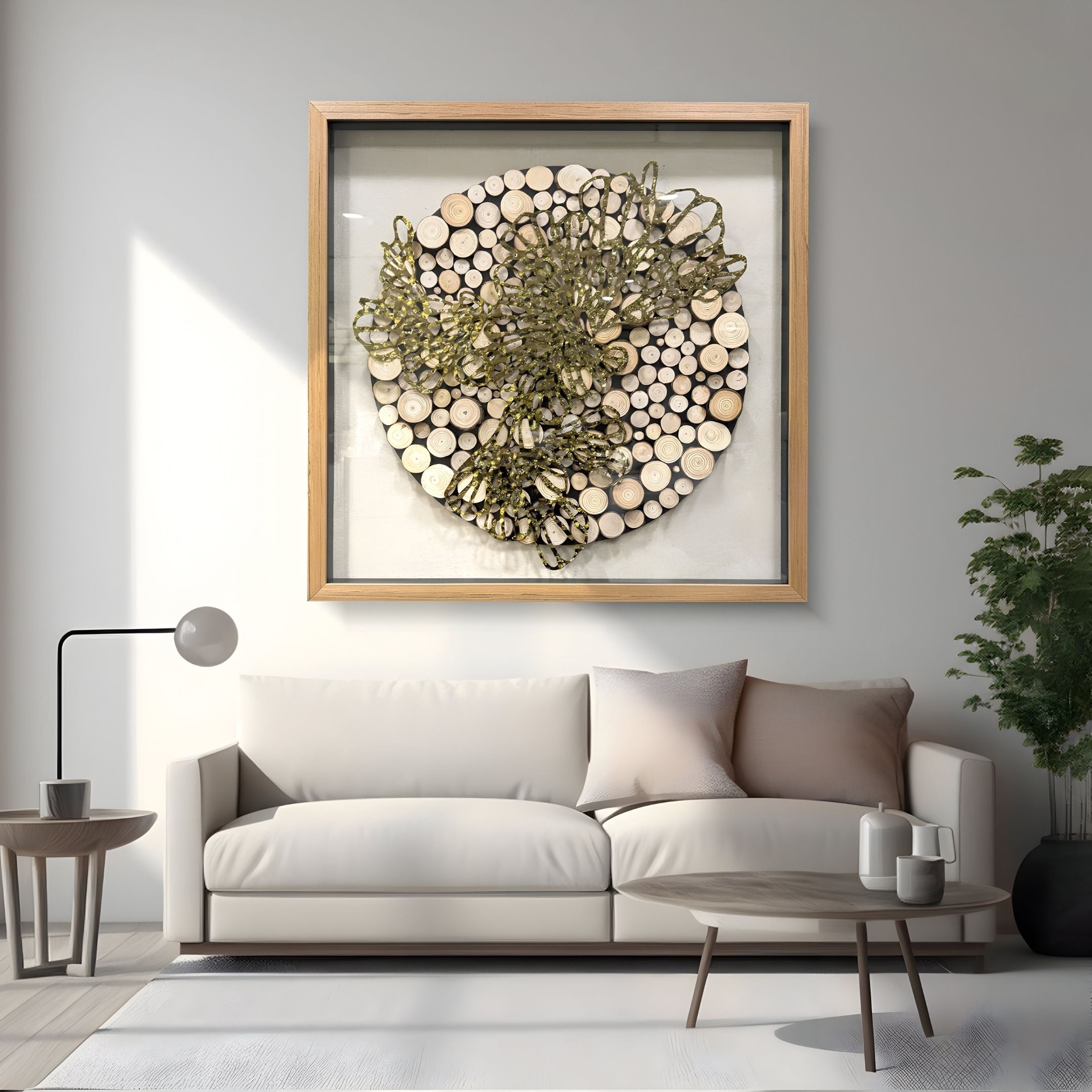 A modern living room with a white sofa, neutral cushions, a round coffee table, and a floor lamp. On the wall hangs Giant Sculptures’ Arborique Radiant Bloom Gold Steel & Wood 3D Wall Art. A green plant sits in the corner.