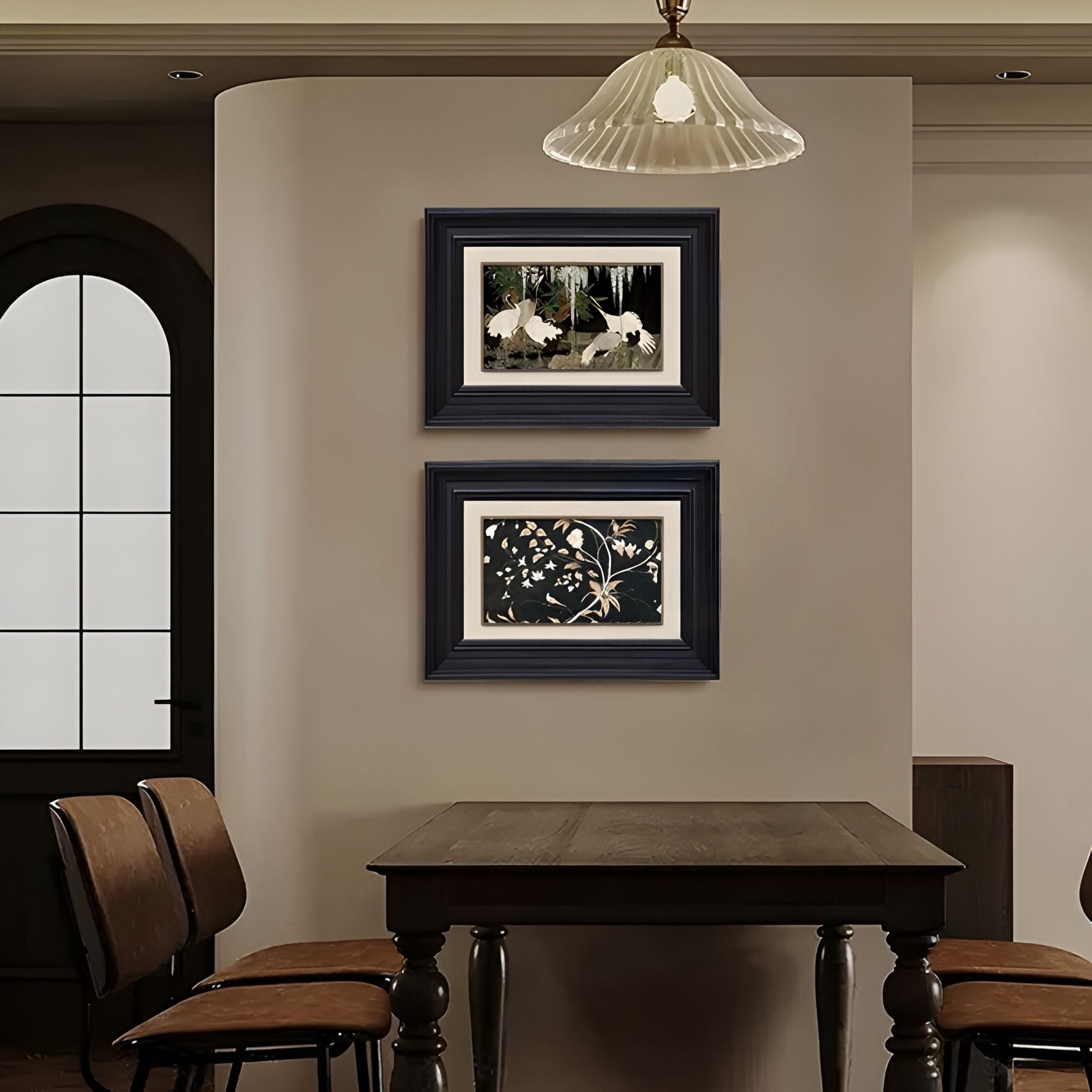 A dining area with a dark wooden table, four chairs, pendant lighting, and the Kansora Woodland & Floral Nature 2-Set Framed Wall Art by Giant Sculptures displayed on a curved beige wall.
