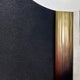 The Vortaryn Charcoal & Concrete Circle Sculptural 3D Wall Art by Giant Sculptures features a textured black surface, smooth metallic gold vertical strip, and rough light gray section on a white curved background.