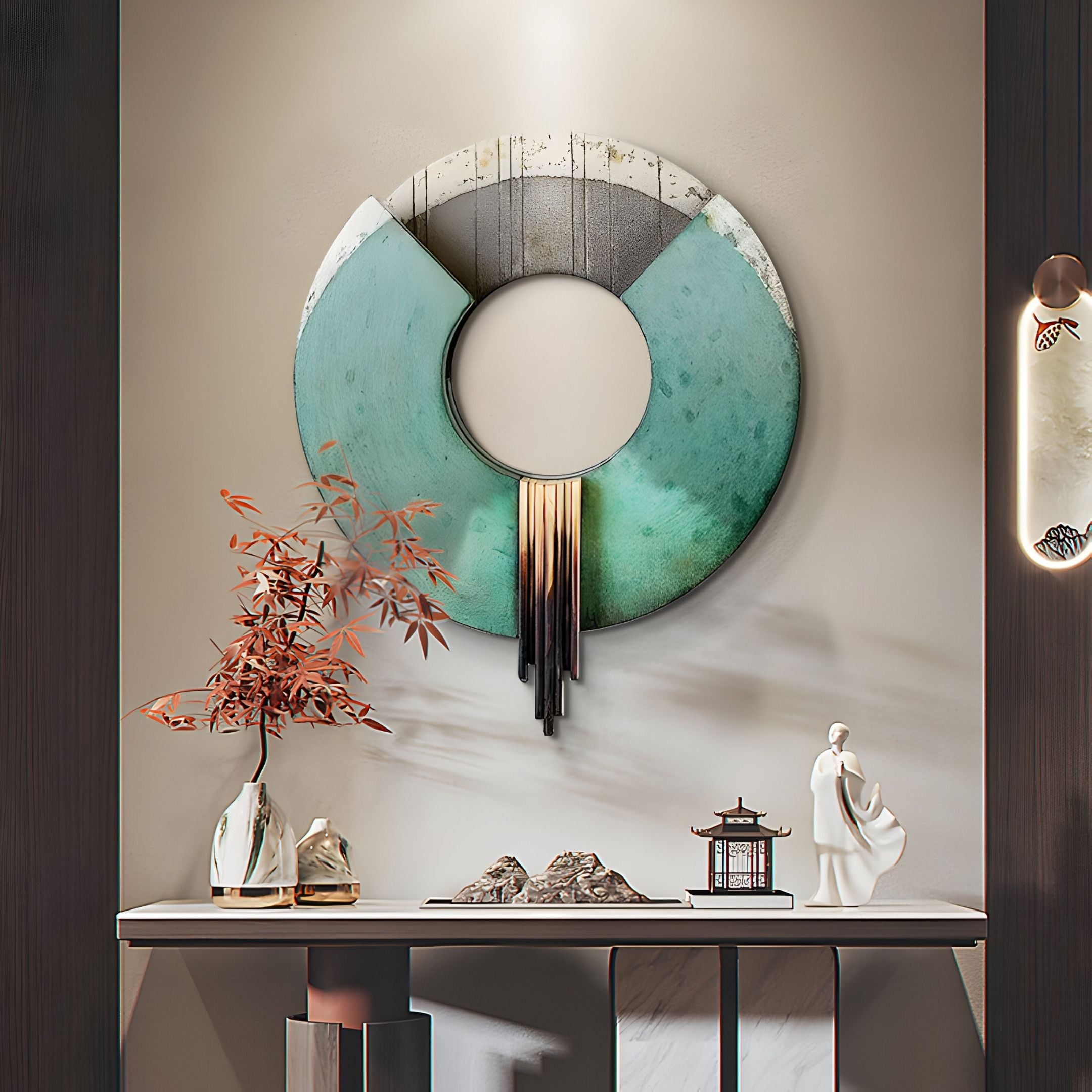 A modern entryway is styled with Giant Sculptures' Vortaryn Verdigris & Steel Circle 3D Wall Art, a vase of orange branches, small sculptures, a pagoda ornament, and a minimalist wall sconce on a neutral wall.