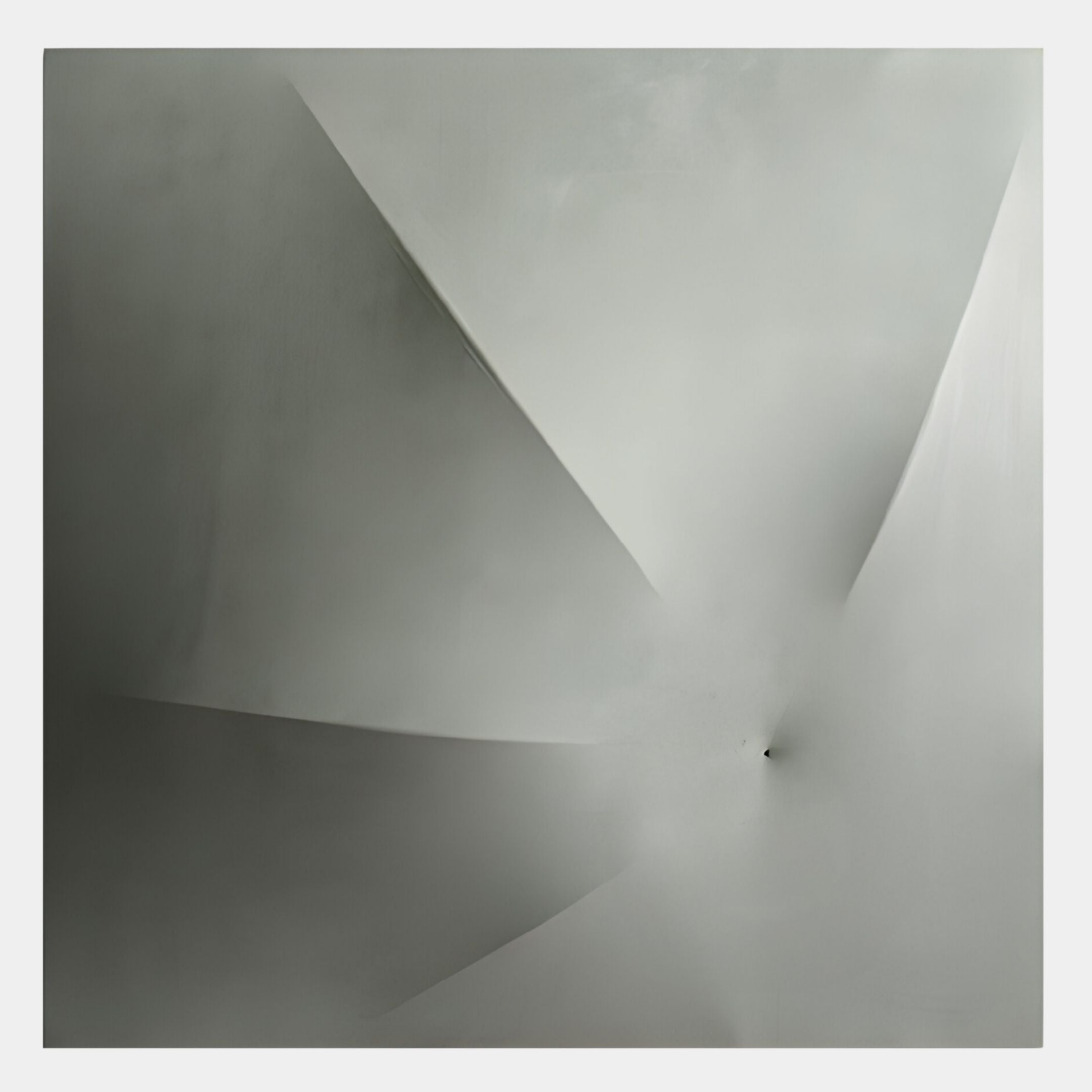 The Veylora Mist Silver Folded Texture Fabric 3D Wall Art by Giant Sculptures features abstract grayscale geometric folds radiating from a single point, embodying sculptural minimalism and depth on a smooth background.