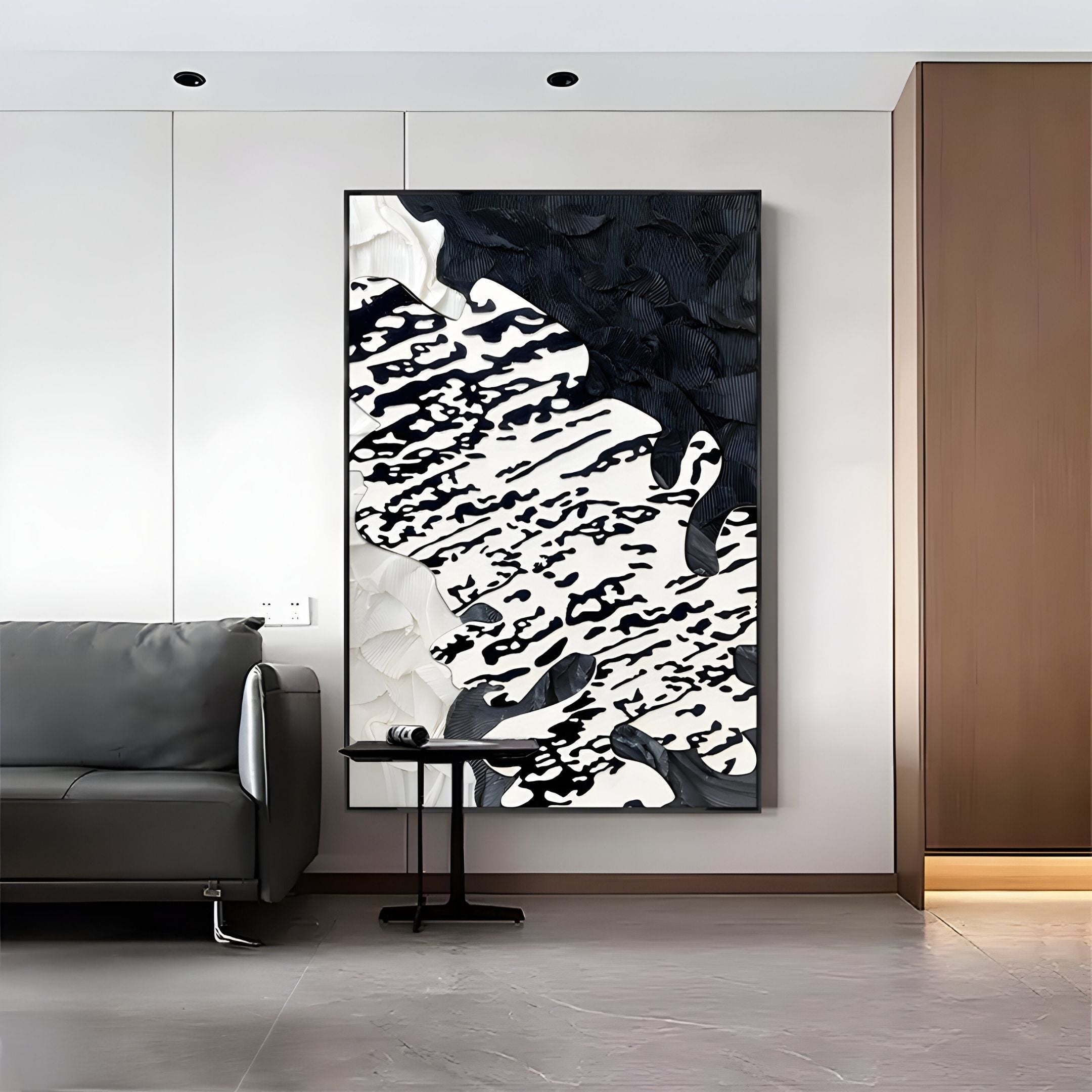A modern living room with a gray sofa, a small round side table, and the Nivoria II Black & White Textured Abstract 3D Wall Art by Giant Sculptures featuring bold brushstrokes and textured patterns for added depth.