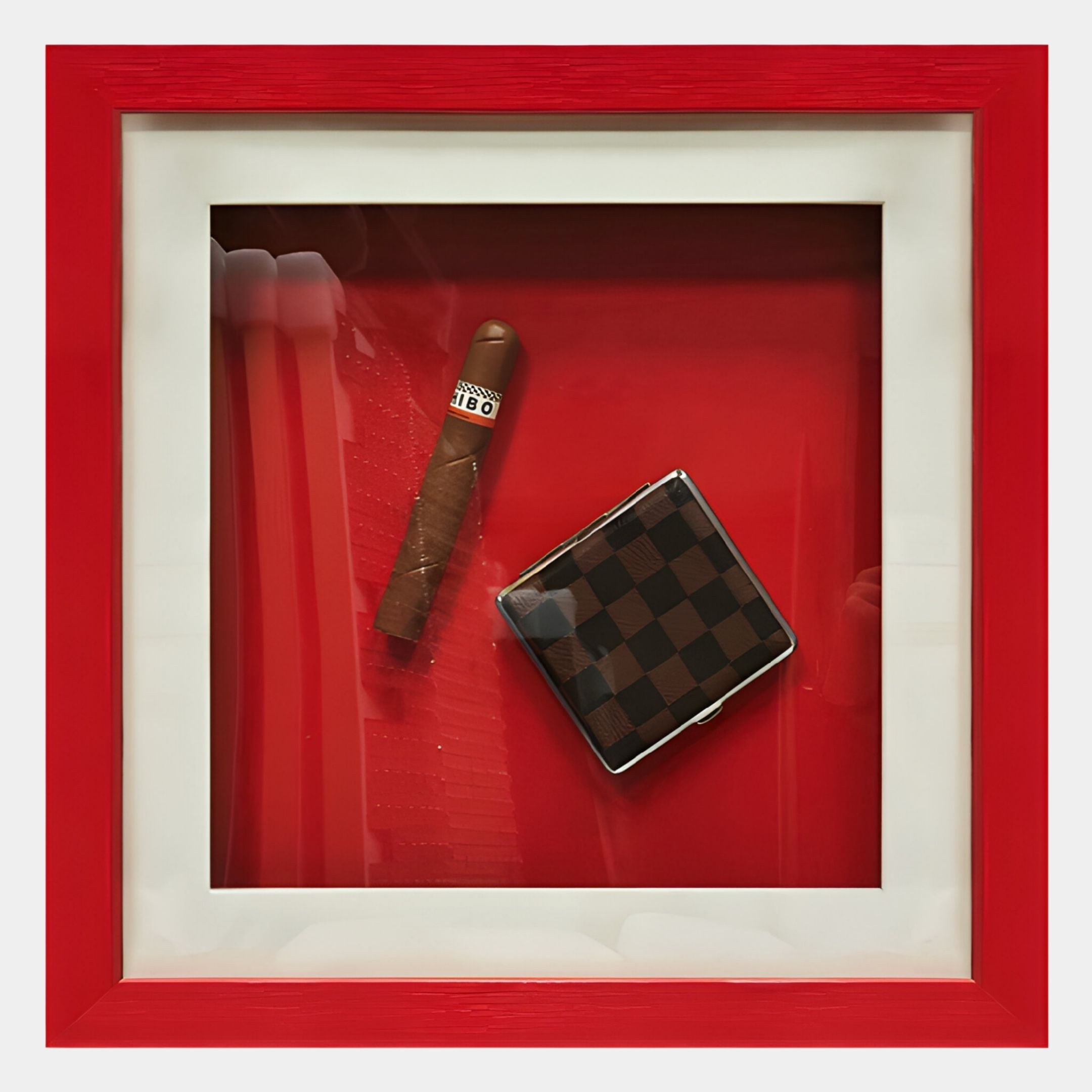 The Cavendro Single Cigar & Checked Case Framed Wall Art by Giant Sculptures features a wrapped cigar and checkered case in a red and white display—ideal vintage-inspired decor or unique wall art for your space.