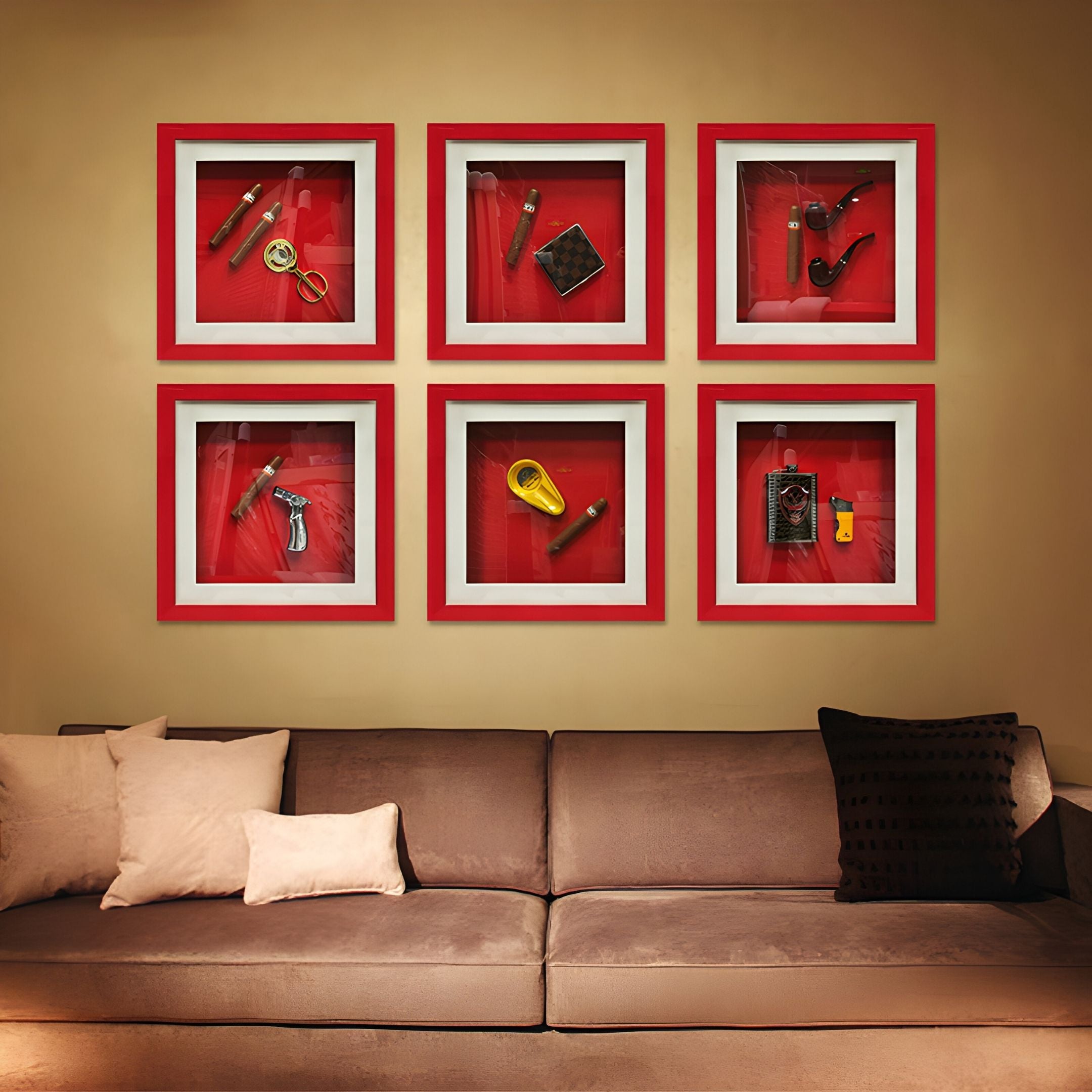 A beige sofa with light and dark pillows sits beneath six red-framed shadow boxes on a tan wall, each displaying vintage items like Giant Sculptures' Cavendro Twin Pipes & Cigar Framed Wall Art, magnifiers, and small tools.