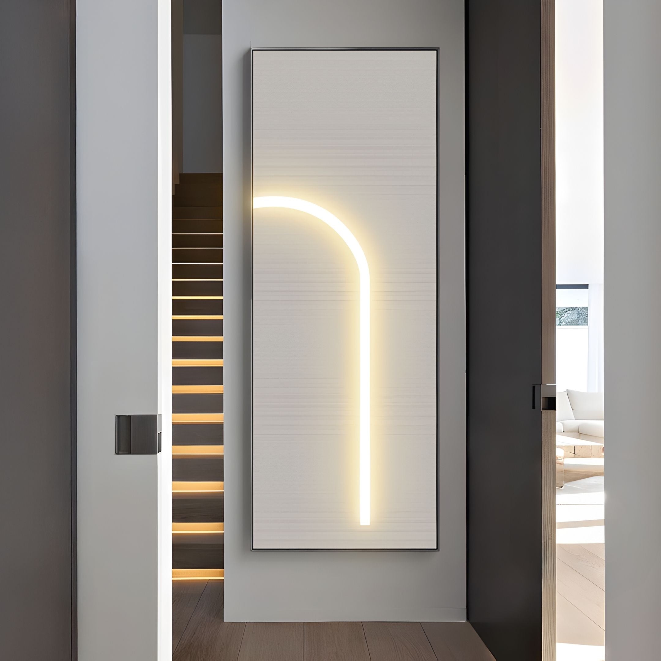 A modern hallway showcases the Giant Sculptures Luminarch Taupe Curve LED Minimalist Wall Art on a textured white wall. Wooden stairs with lit steps ascend, while a bright living area opens up in the background.