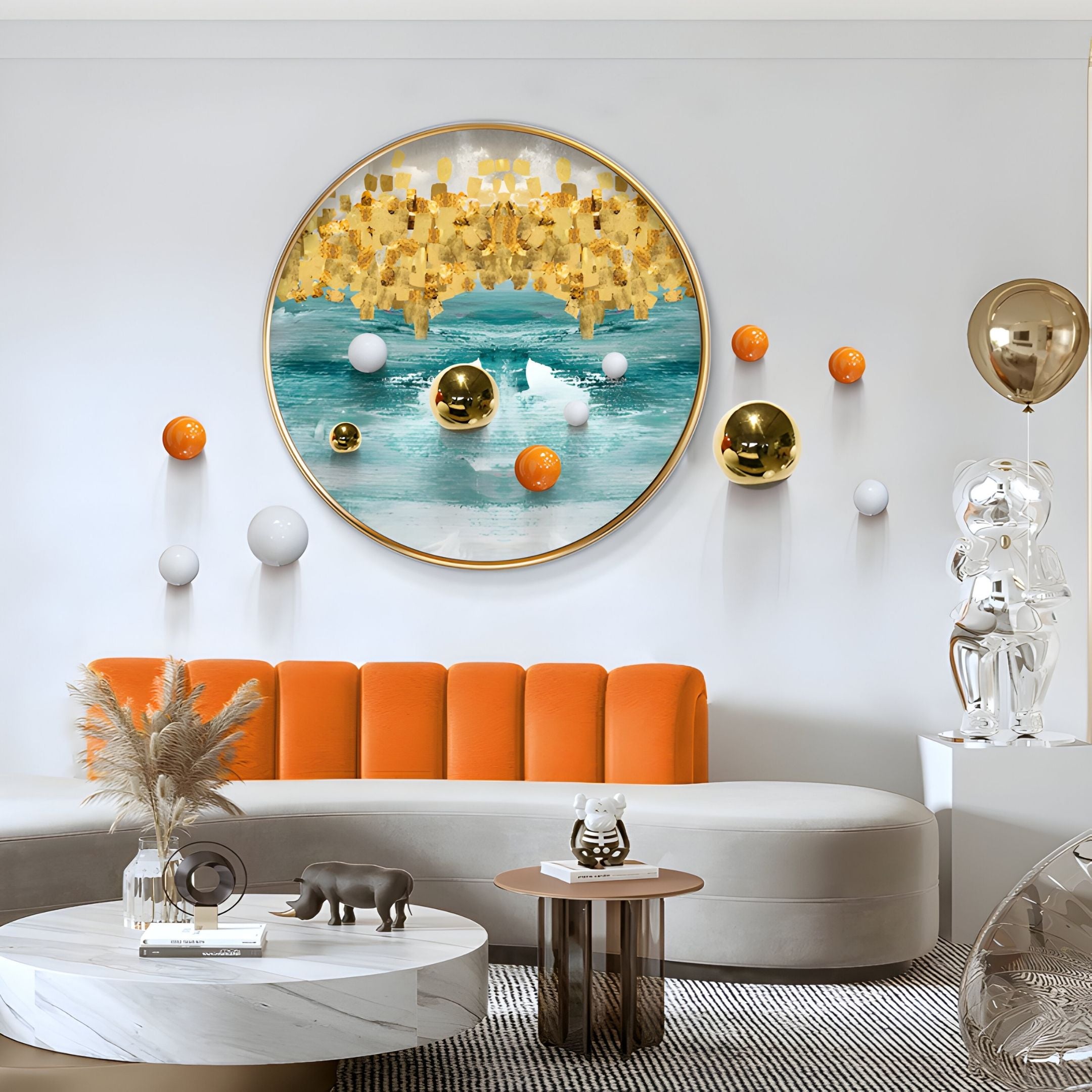 A modern living room featuring a curved gray sofa with orange backrest, round marble coffee table, and Aurellune Teal & Gold Drift 3D Wall Art With Metal Balls by Giant Sculptures for a bold contemporary touch.