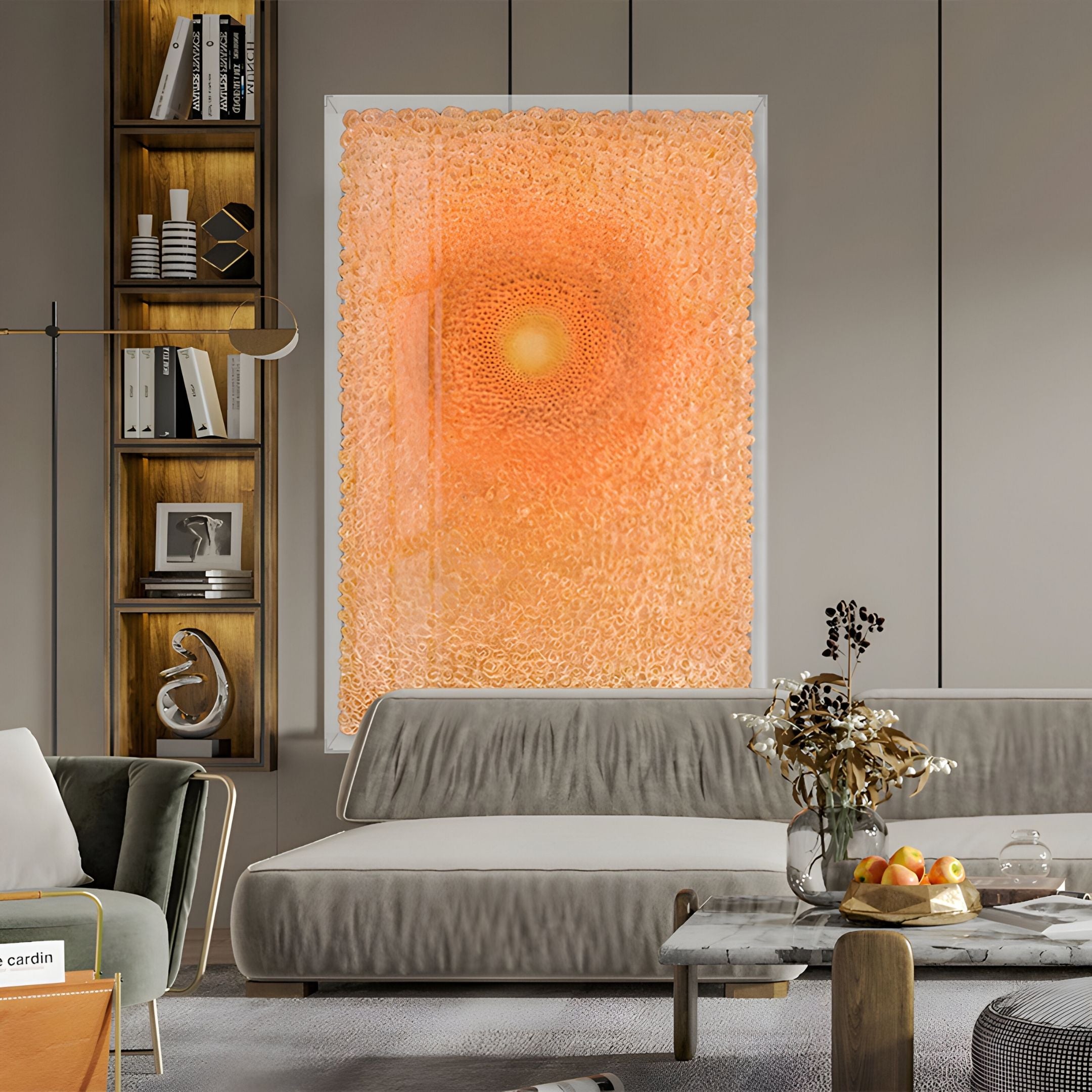A modern living room with a gray sofa, a Giant Sculptures Lumora Amber Orange Acrylic Framed 3D Paper Wall Art, a marble coffee table with decor, and built-in wooden shelves with books and decorative items.