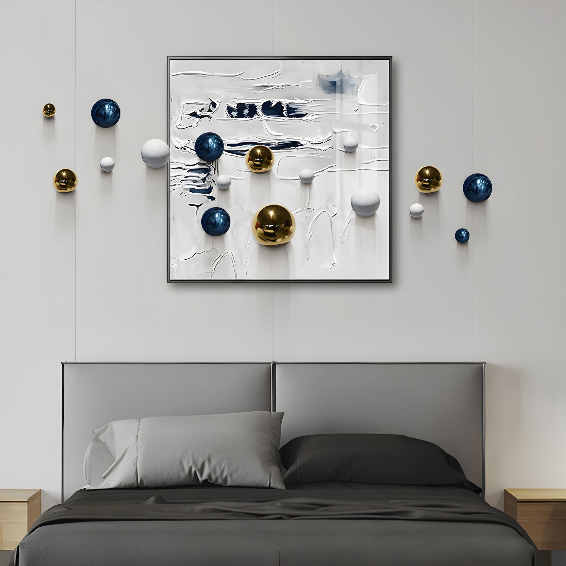 A modern bedroom with a gray bed, gray bedding, and light wood nightstands features Aeroluxe Navy & White Abstract 3D Wall Art With Metal Balls by Giant Sculptures—blue, gold, and white spheres on textured white above the bed and on the wall.