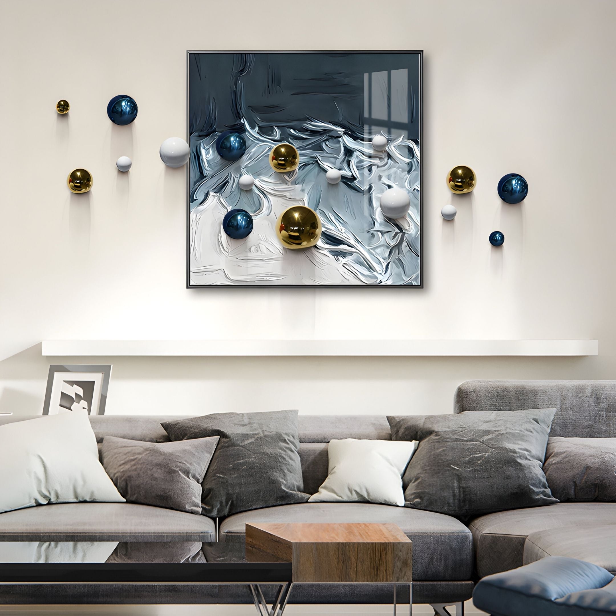A modern living room with a gray sectional sofa, gray and white cushions, a wooden coffee table, and Giant Sculptures' Aeroluxe Deep Blue Wave 3D Wall Art featuring metallic balls extending from the abstract square piece.