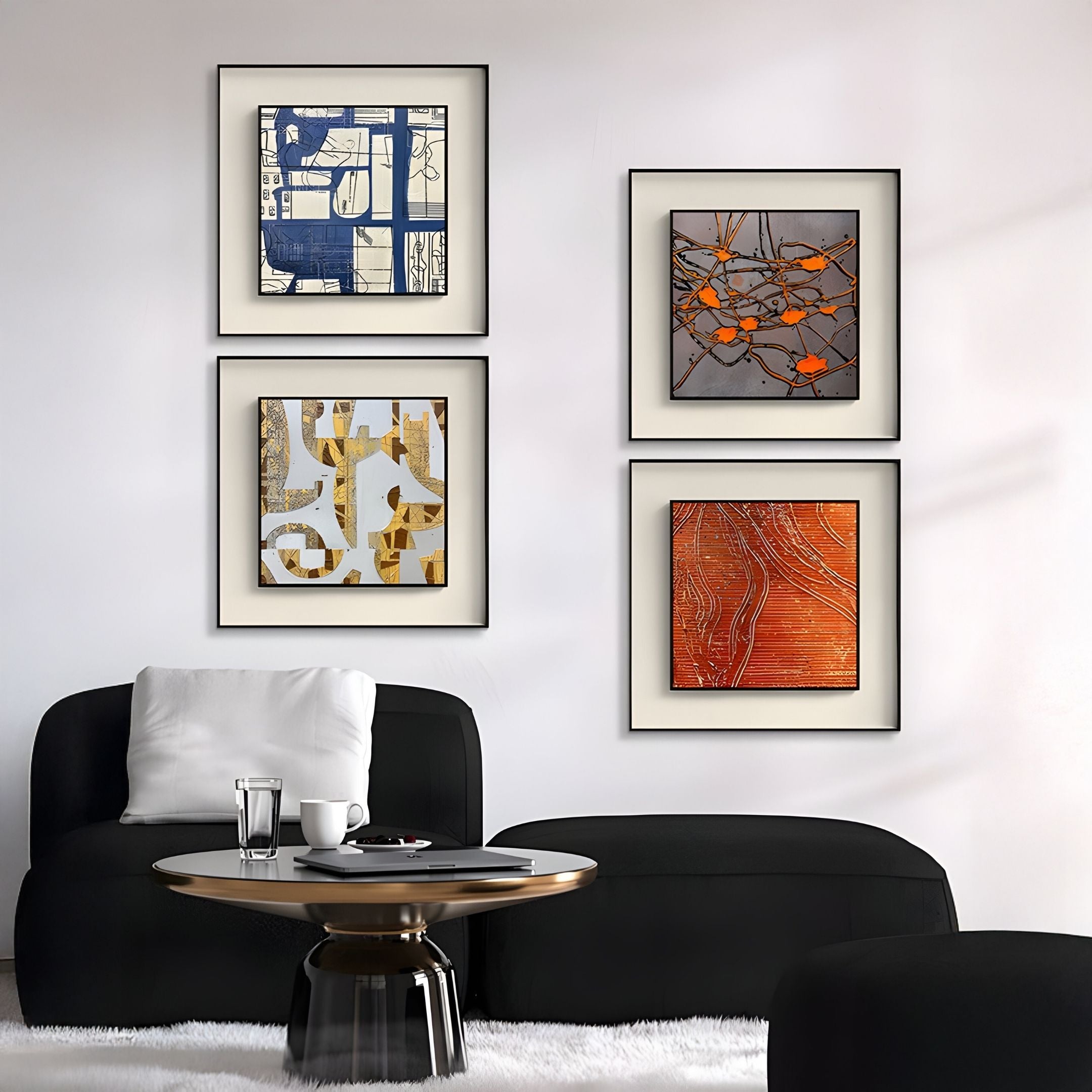 A modern living room with black chairs, a round black coffee table, and four abstract textured framed art pieces—two blue and gold designs, and two Giant Sculptures Stratonis Orange Drip Abstract Textured Framed Wall Arts—on a white wall.