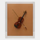 The Archetto Terra Violin Acrylic Framed 3D Wall Art by Giant Sculptures features a violin and bow mounted diagonally on an orange-brown backdrop in a transparent acrylic frame, creating striking and elegant wall art.