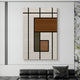 The Gridoria Cocoa Brown & Olive Linear Block Woven Wall Art by Giant Sculptures, with geometric black lines and earthy hues, hangs above a black leather sofa in a minimalist living room.